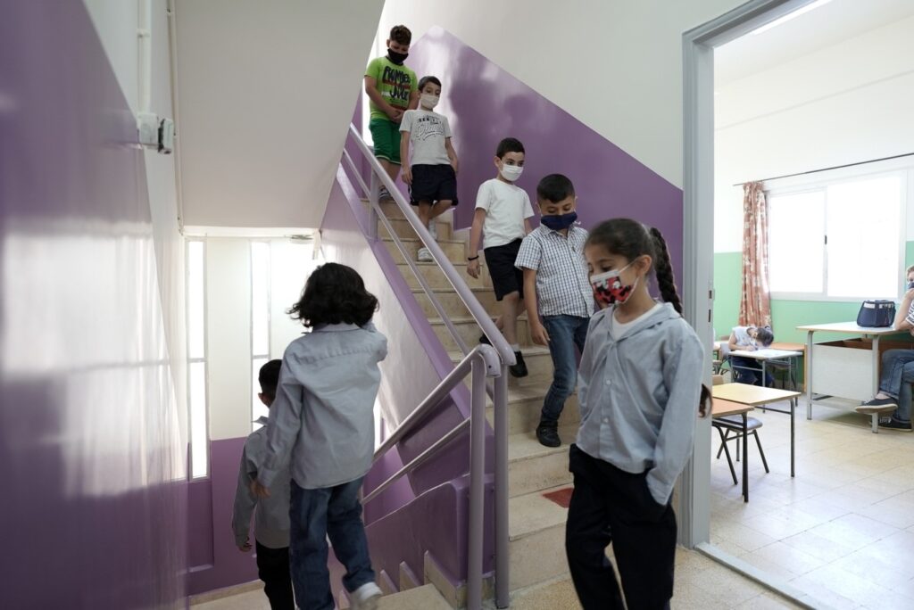 children going down the stairs in a renovated public school