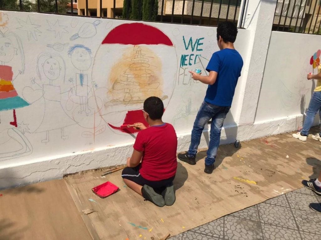 Children painting a mural in the playground of St George Assyrian School in Beirut, which was damaged by the port blasts and rehabilitated by UNESCO. Activity conducted by UNESCO and UN-Habitat. © UNESCO, 2021